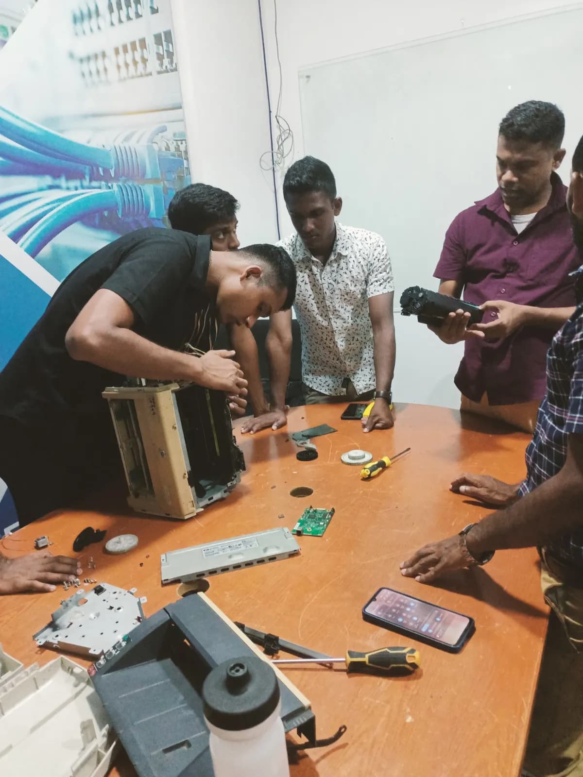 Students disassembling and repairing hardware in a practical lab session