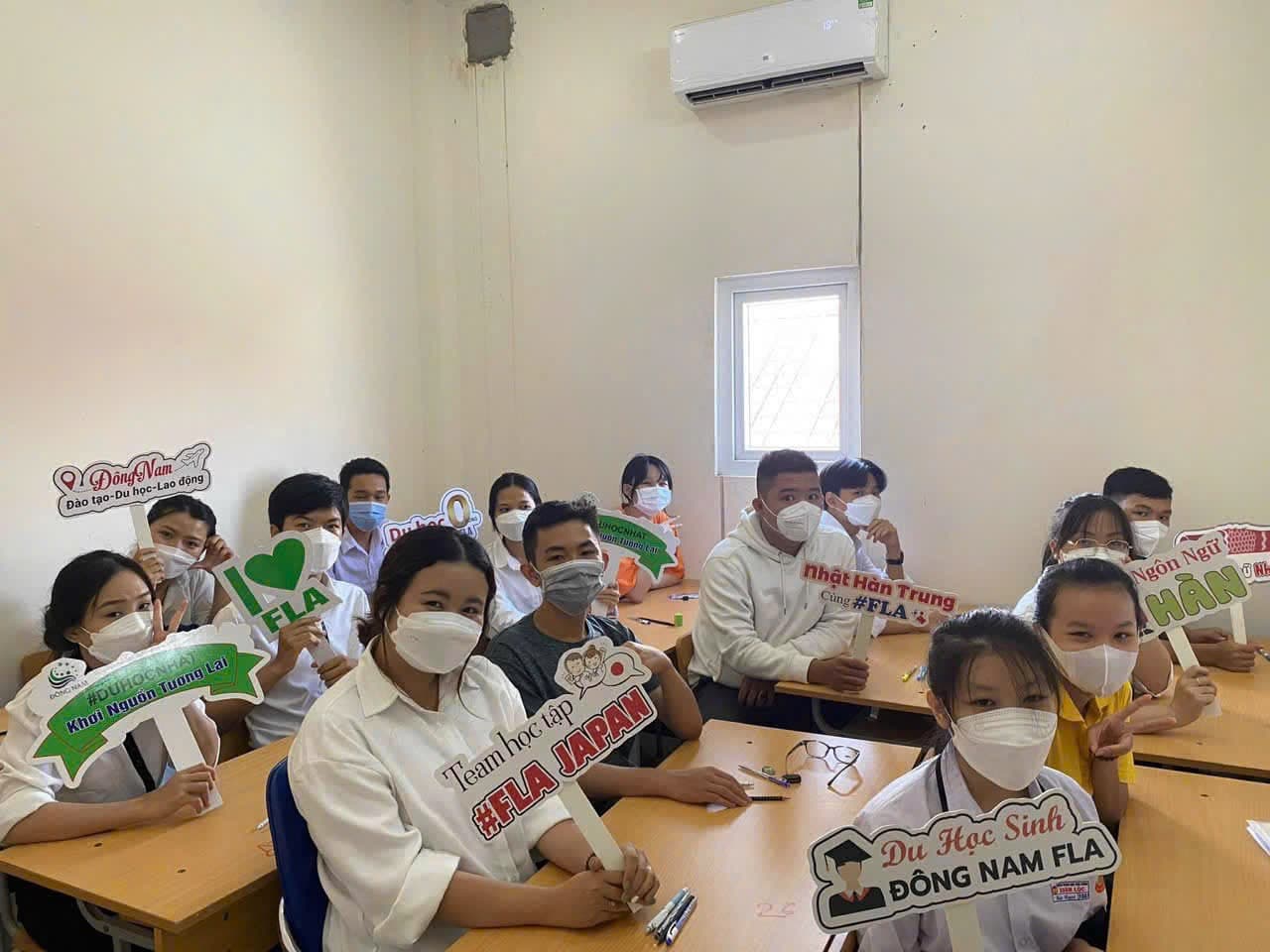Study-abroad class holding Đông Nam FLA pathway signage