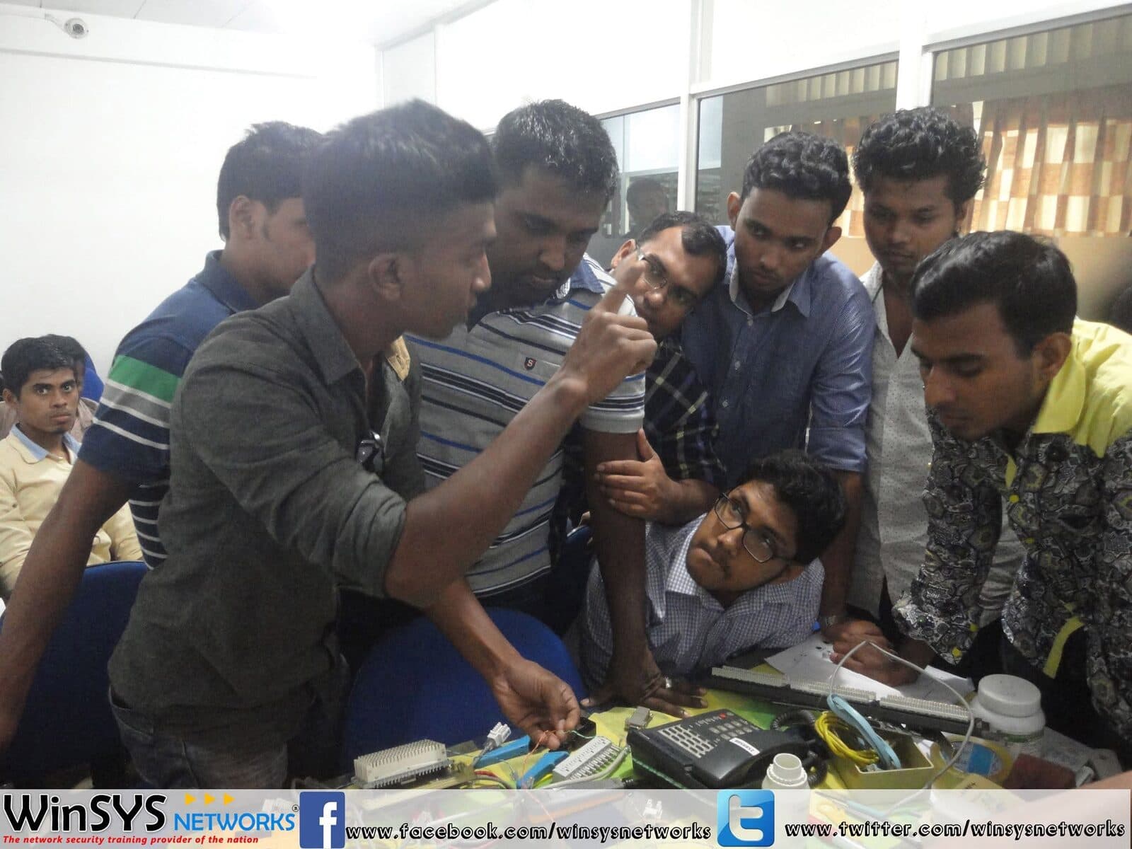 Students gathered around an instructor terminating network cable on a punch-down block